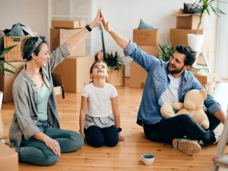 Glückliche Eltern und ihre Tochter stehen vor ihrem neuen Haus, das sie nach einem Umzug mit Hilfe von A2B Umzüge bezogen haben.